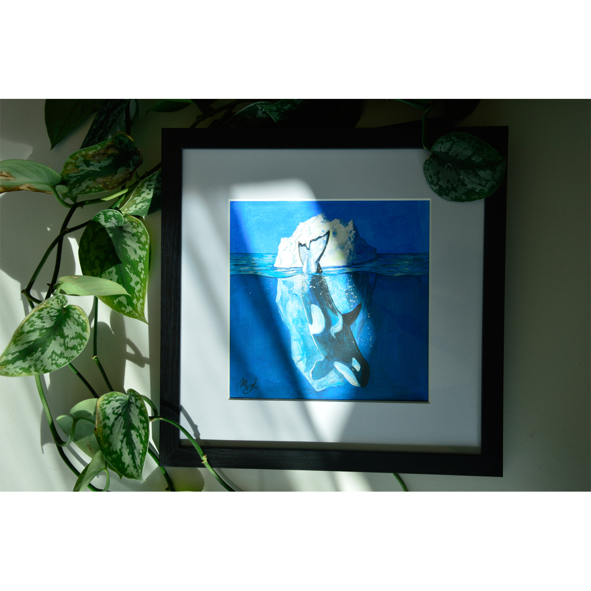 Framed painting of a killer whale into the blue and iceberg behind.